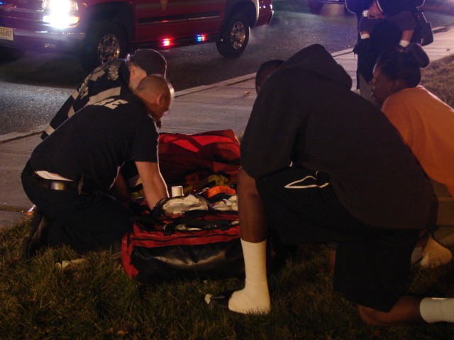 Firefighter Jamie Clark provides medical aid to the victim of a motor vehicle accident