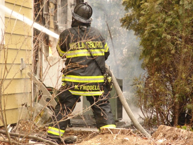 Firefighter Marc Friddell operating a hose line at a house fire on Hadley Lane