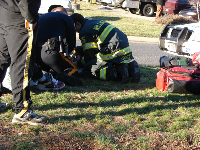 Firefighter Jason Carty provides medical care to the victim of a motor vehicle accident