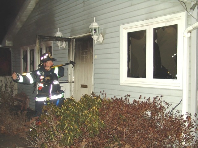 Captain Sitzenstock forcing a door at a house fire on Sedgewick Lane