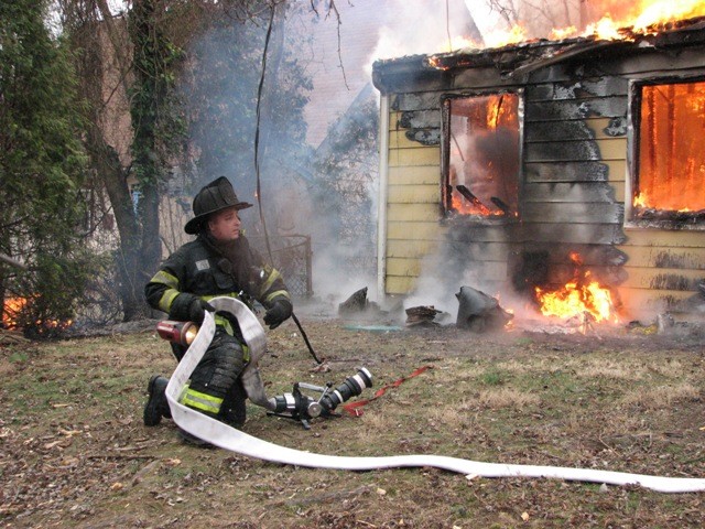 Firefighter Joe Fresco sets up a 2 1/2&quot; hose line at a house fire on Hadley Lane