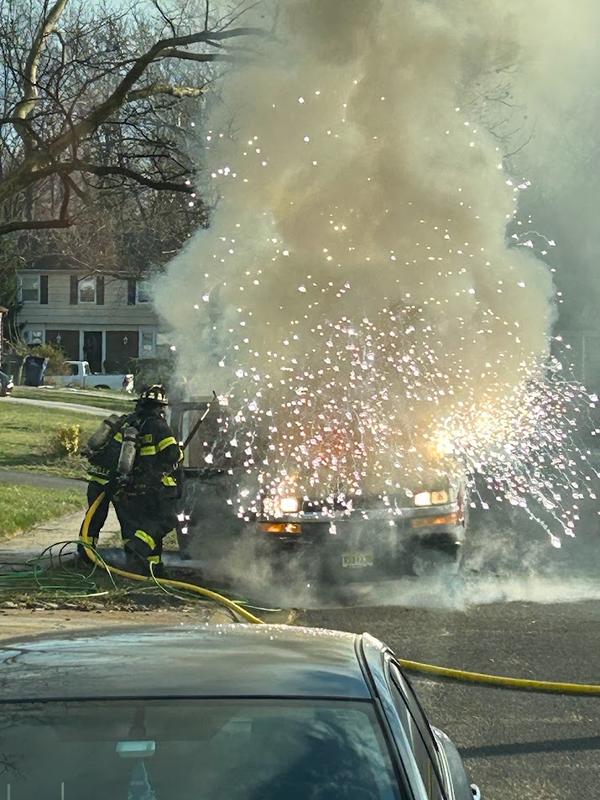 Firefighters Connelly and Bowe extinguishing a utility van on fire.