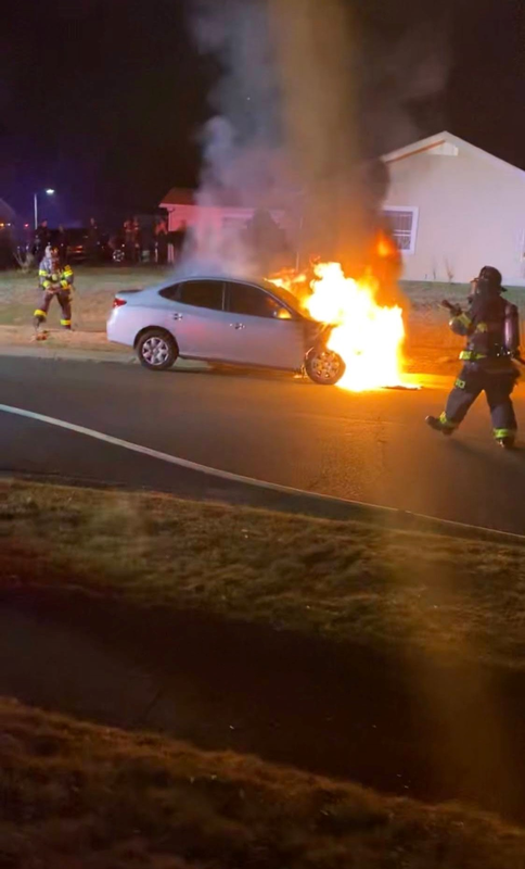 Firefighters Connelly and LeHuquet extinguishing a vehicle fire.