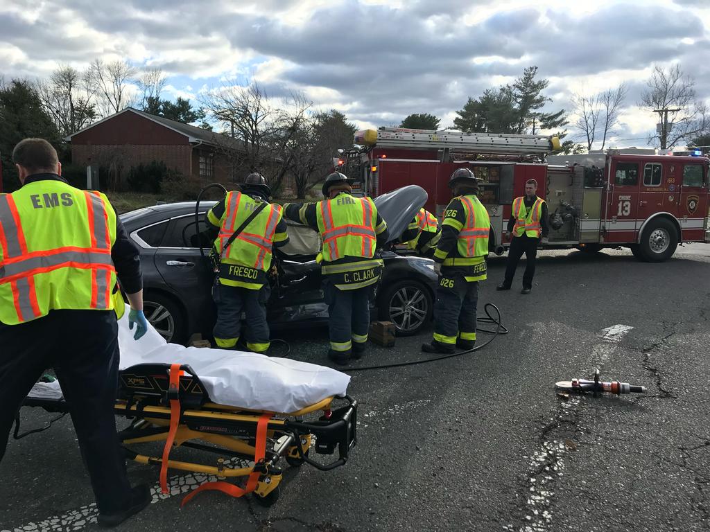 Firefighters stabilizing the vehicle and preparing to begin extricating a victim at an auto accident.