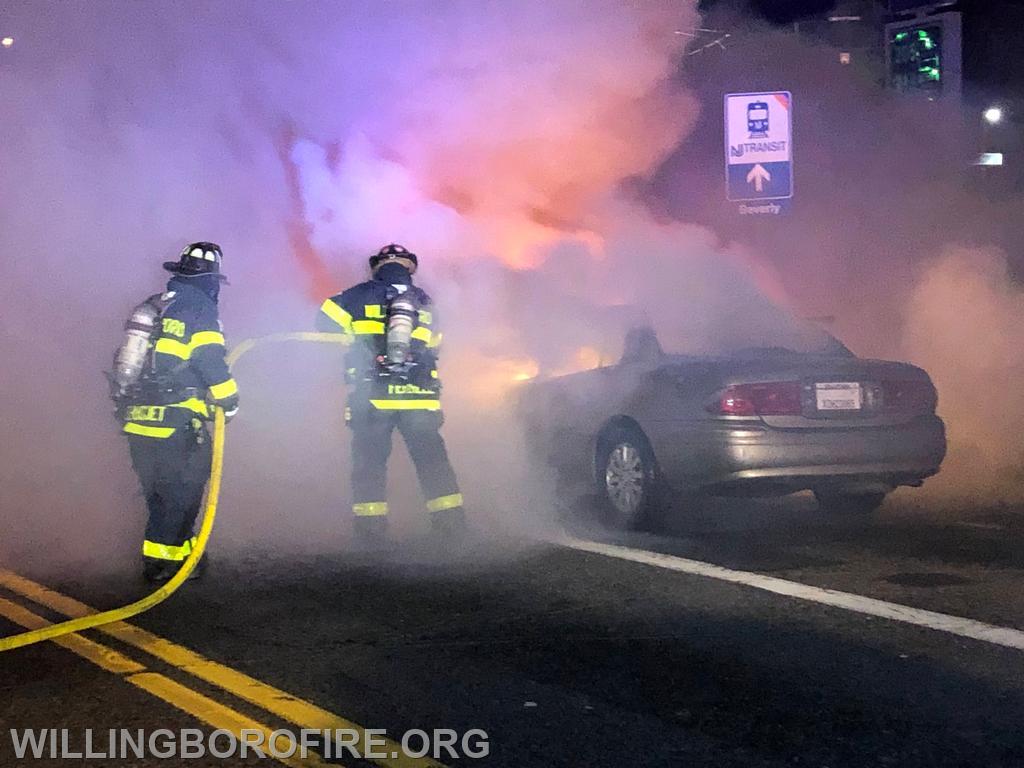 Firefighters extinguishing a car fire.