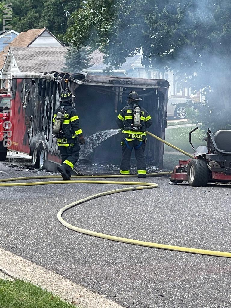 Firefighter Connelly and Barger extinguishing a landscape trailer on fire