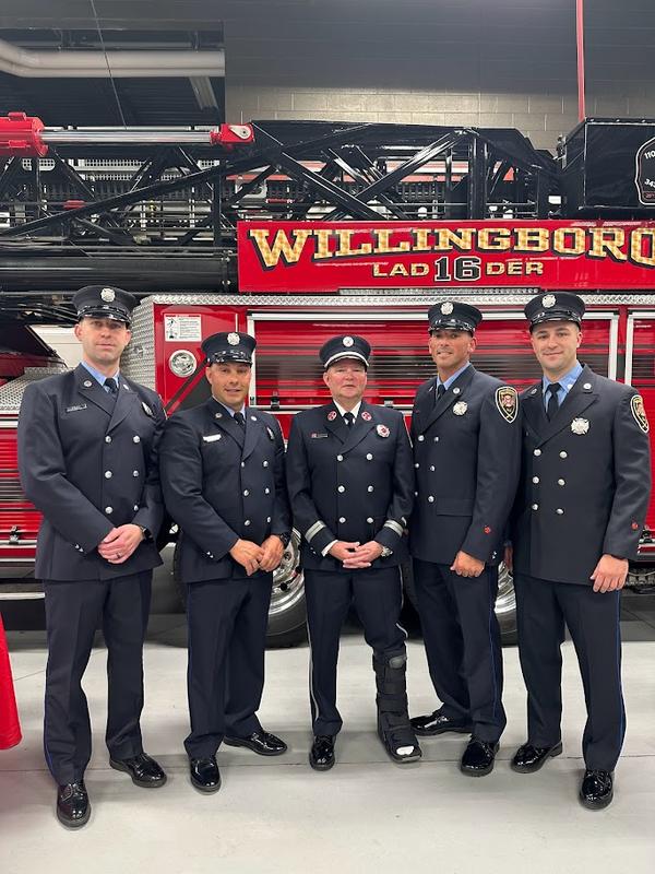 Firefighters gathering around Captain Brian Gardner at his retirement ceremony.