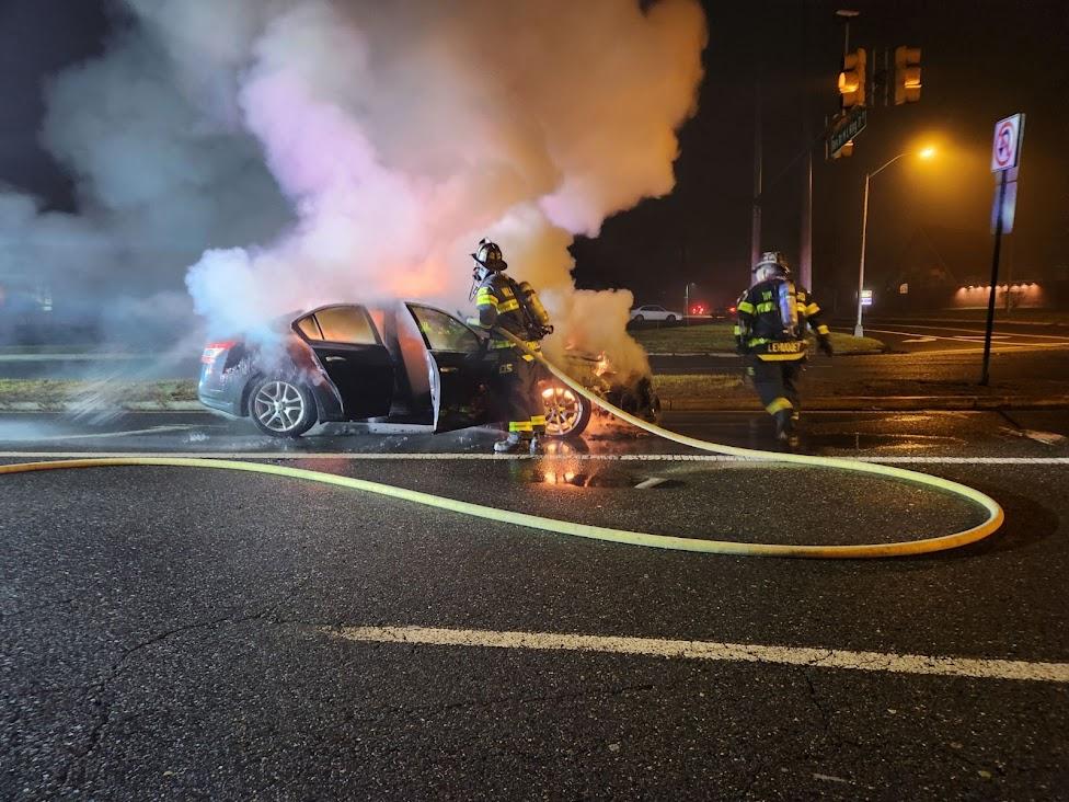 Firefighter Connelly and Lehuquet extinguishing an auto fire on Veterans Parkway.