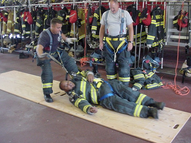 Firefighter Fresco pulls Firefighter Blackwell as Captain Sitzenstock looks on during Personal Harness Training