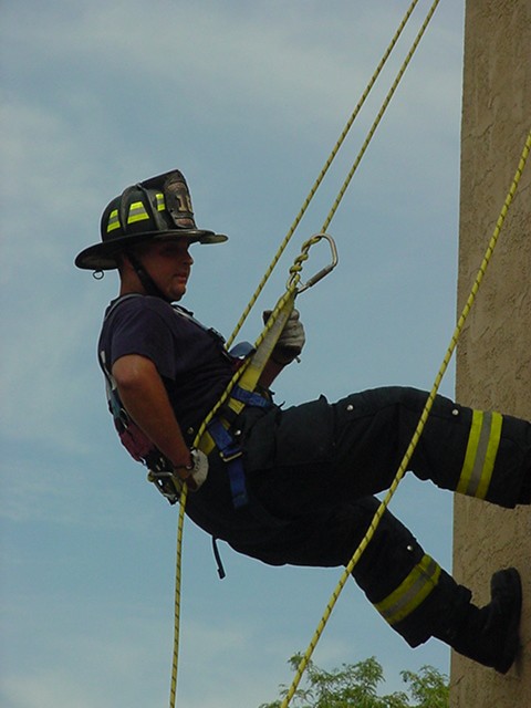 Firefighter Fresco coming down the side of Station 163 using his personal harness and rope