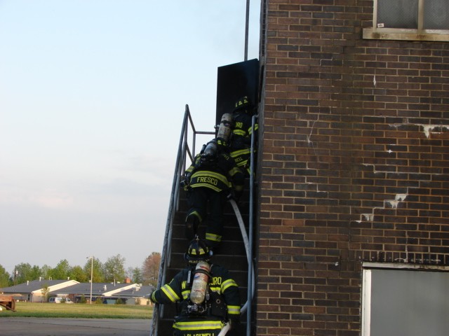 Firefighters entering the burn building through the outside stairs